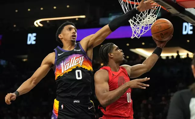 Portland Trail Blazers guard Scoot Henderson (00) drives past Phoenix Suns forward Royce O'Neale during the first half of an NBA basketball game, Sunday, Feb. 22, 2026, in Phoenix. (AP Photo/Rick Scuteri)