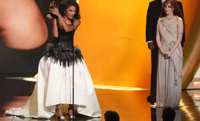 Olivia Dean accepts the award for best new artis during the 68th annual Grammy Awards on Sunday, Feb. 1, 2026, in Los Angeles. Chappell Roan looks on from right. (AP Photo/Chris Pizzello)