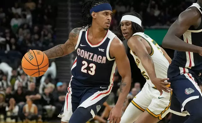 Gonzaga guard Adam Miller (23) drives to the basket against San Francisco guard Tyrone Riley IV during the first half of an NCAA college basketball game in San Francisco, Wednesday, Feb. 18, 2026. (AP Photo/Jeff Chiu)
