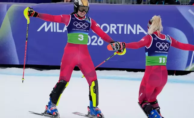 Austria's Katharina Huber, left, celebrates with Austria's Katharina Truppe at the finish area of an alpine ski, women's team combined race, at the 2026 Winter Olympics, in Cortina d'Ampezzo, Italy, Tuesday, Feb. 10, 2026. (AP Photo/Andy Wong)