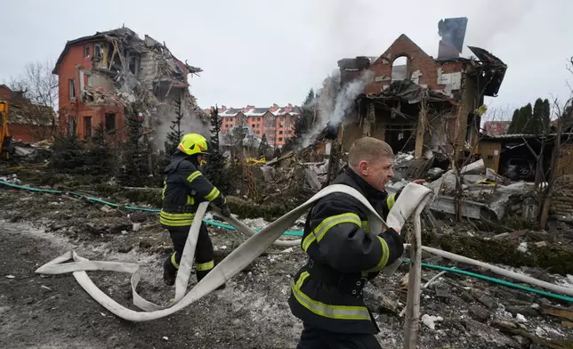Firefighters put out a fire after a drone hit a residential building during a Russian air attack in Kyiv, Ukraine, Sunday, Feb. 22, 2026. (AP Photo/Sergei Grits)