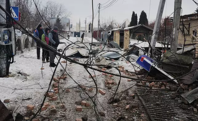 Local residents react after a Russian drone attack that damaged residential buildings in Kyiv, Ukraine, Sunday, Feb. 22, 2026. (AP Photo/Sergei Grits)