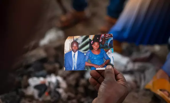 People look at pictures of Nguvumali Kalabosh Bosco, who died when tunnels collapsed at a major coltan mining site due to landslides, in Goma, eastern Congo, Monday, Feb. 2, 2026. (AP Photo/Moses Sawasawa)