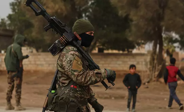 Members of the Syrian army stands at a checkpoint in the town of Sarin, where government forces were already present, as additional units move toward al-Hasakah to implement an agreement with the Kurdish-led Syrian Democratic Forces (SDF) aimed at stabilizing a ceasefire, in al-Hasakah province, eastern Syria, Monday, Feb. 2, 2026. (AP Photo/Ghaith Alsayed)