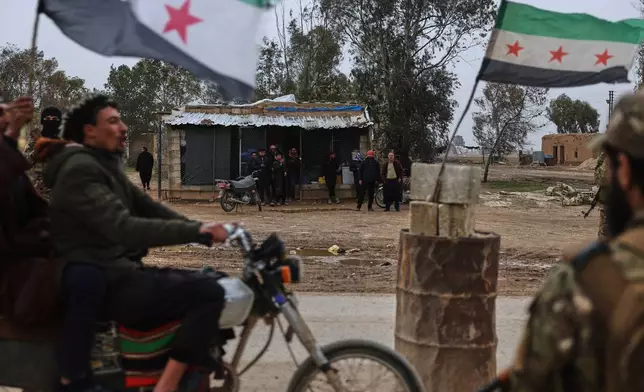 Members of the Syrian army stand at a checkpoint in the town of Sarin, where government forces were already present, as additional units move toward al-Hasakah to implement an agreement with the Kurdish-led Syrian Democratic Forces (SDF) aimed at stabilizing a ceasefire, in al-Hasakah province, eastern Syria, Monday, Feb. 2, 2026. (AP Photo/Ghaith Alsayed)