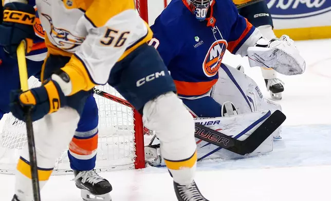 New York Islanders goalie Ilya Sorokin, right, keeps his eye on Nashville Predators forward Erik Haula, with puck, during the first period of an NHL hockey game Saturday, Jan. 31, 2026, in Elmont, N.Y. (AP Photo/John Munson)