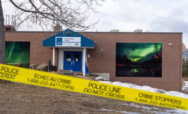 Police tape surrounds a school in Tumbler Ridge, British Columbia, Canada, on Thursday, Feb. 12, 2026, after Tuesday's mass shooting. (Christinne Muschi/The Canadian Press via AP)