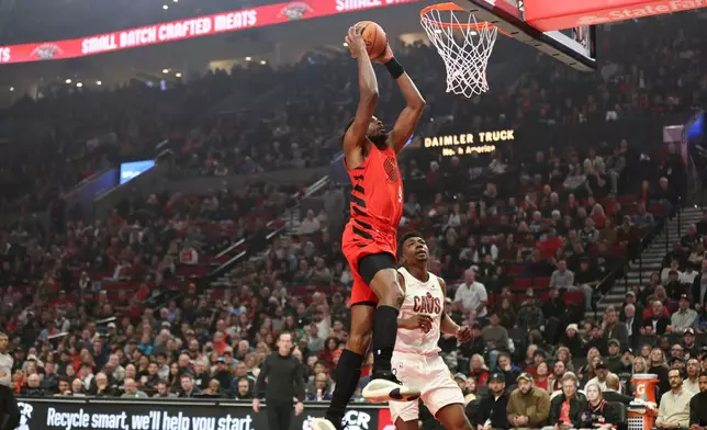 Portland Trail Blazers forward Jerami Grant (9) drives to the basket past Cleveland Cavaliers center Thomas Bryant during the first half of an NBA basketball game, Sunday, Feb. 1, 2026, in Portland, Ore. (AP Photo/Amanda Loman)