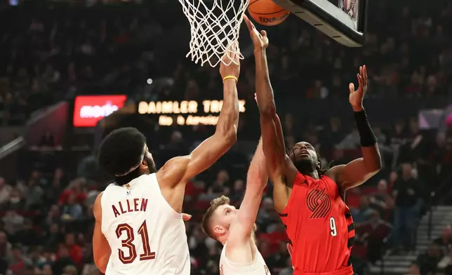 Portland Trail Blazers forward Jerami Grant, right, drives to the basket beside Cleveland Cavaliers forward Dean Wade, center, and center Jarrett Allen, right, during the first half of an NBA basketball game, Sunday, Feb. 1, 2026, in Portland, Ore. (AP Photo/Amanda Loman)