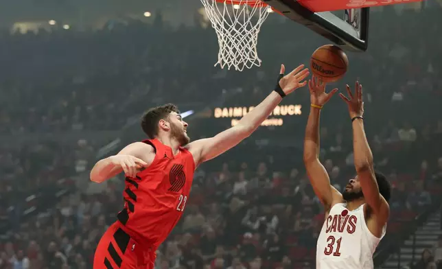 Portland Trail Blazers center Donovan Clingan (23) and Cleveland Cavaliers center Jarrett Allen (31) grab for a rebound during the first half of an NBA basketball game Sunday, Feb. 1, 2026, in Portland, Ore. (AP Photo/Amanda Loman)