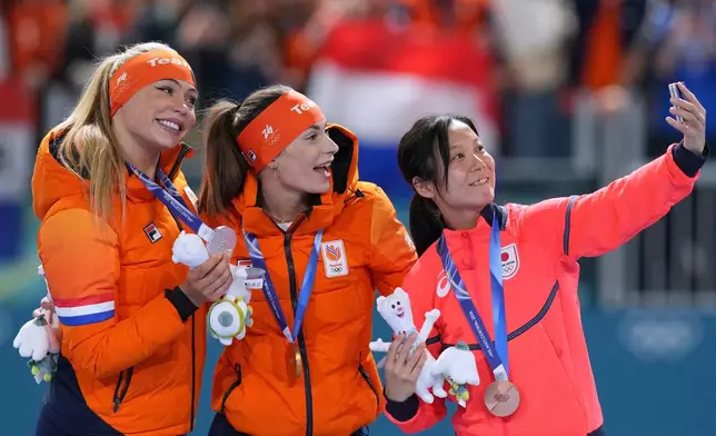 Femke Kok of the Netherlands, center and gold medal, Jutta Leerdam of the Netherlands, left and silver medal, and Miho Takagi of Japan, right and bronze medal, celebrate on the podium of the women's 500 meters speedskating race at the 2026 Winter Olympics, in Milan, Italy, Sunday, Feb. 15, 2026. (AP Photo/Antonio Calanni)