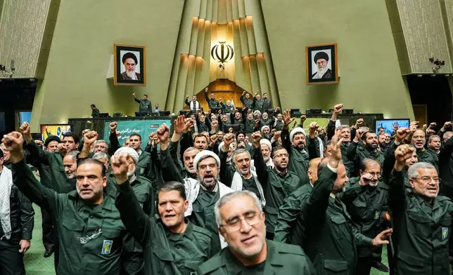 In this handout photo released by the Islamic Consultative Assembly News Agency (ICANA) Iranian lawmakers chant slogans as they wear the Revolutionary Guard's uniform in a session of parliament, in Tehran, Iran, Sunday, Feb. 1, 2026. (Hamed Malekpour/ICANA via AP)