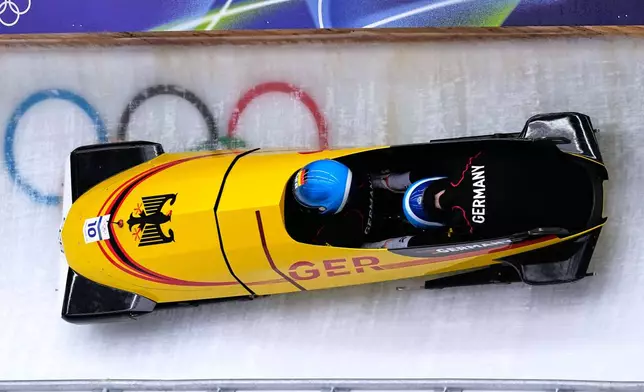 Germany's Francesco Friedrich, left, slides down the track during a two man bobsled training session at the 2026 Winter Olympics, in Cortina d'Ampezzo, Italy, Saturday, Feb. 14, 2026. (AP Photo/Aijaz Rahi)