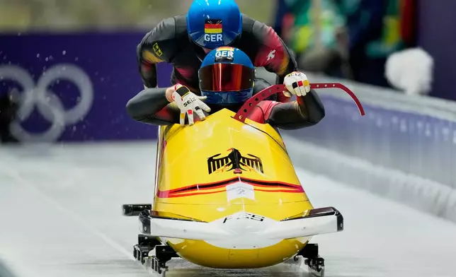 Germany's Francesco Friedrich, right, and Alexander Schuller start for a two man bobsled run at the 2026 Winter Olympics, in Cortina d'Ampezzo, Italy, Monday, Feb. 16, 2026. (AP Photo/Alessandra Tarantino)