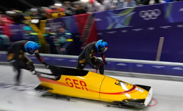 Germany's Adam Ammour, right, and Alexander Schaller start for a two man bobsled run at the 2026 Winter Olympics, in Cortina d'Ampezzo, Italy, Monday, Feb. 16, 2026. (AP Photo/Aijaz Rahi)