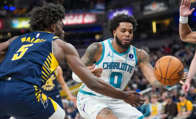 Charlotte Hornets forward Miles Bridges (0) looses the ball in front of Indiana Pacers forward Jarace Walker (5) during the first half of an NBA basketball game in Indianapolis, Thursday, Feb. 26, 2026. (AP Photo/AJ Mast)