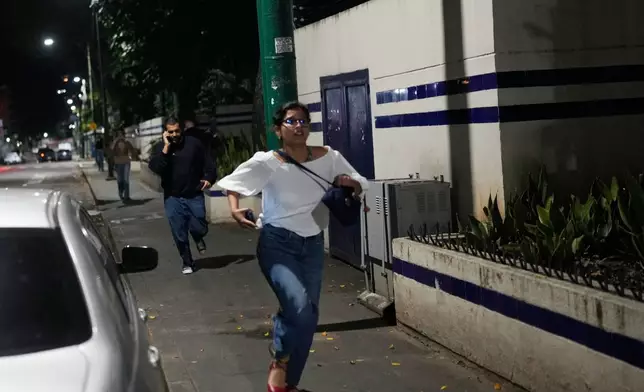 FILE - Pedestrians run after explosions and low-flying aircraft were heard in Caracas, Venezuela, Jan. 3, 2026. (AP Photo/Matias Delacroix, File)