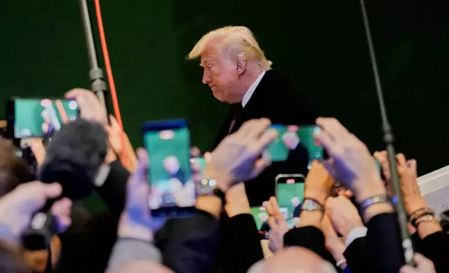 FILE - U.S. President Donald Trump is photographed by a gaggle of journalists at the World Economic Forum annual meeting in Davos, Switzerland, Jan. 22, 2026. (AP Photo/Markus Schreiber, File)