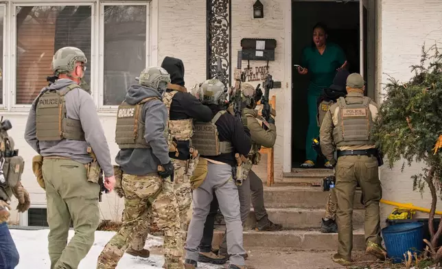 FILE - Teyana Gibson Brown, standing in her doorway, reacts after a federal immigration officer used a battering ram to break down her front door before arresting her husband, in Minneapolis, Jan. 11, 2026. (AP Photo/John Locher, File)