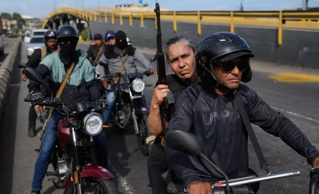 FILE - Pro-government armed civilians patrol in La Guaira, Venezuela, Jan. 3, 2026, just hours after President Nicolás Maduro was captured by US forces and flown out of the country. (AP Photo/Matias Delacroix, File)