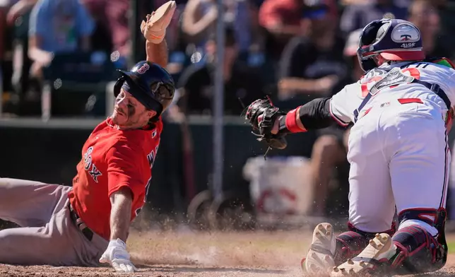 Boston Red Sox's Braiden Ward scores past Minnesota Twins catcher Andrew Cossetti in the seventh inning of a spring training baseball game in Fort Myers, Fla., Saturday, Feb. 21, 2026. (AP Photo/Gerald Herbert)