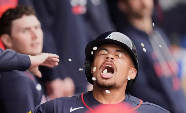 Atlanta Braves Drake Baldwin tries to catch pumpkin seeds as he is greeted in the dugout after hitting a solo home run in the third inning of a spring training baseball game against the Minnesota Twins in North Port, Fla., Sunday, Feb. 22, 2026. (AP Photo/Gerald Herbert)