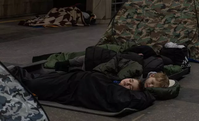 People take shelter in a metro station, being used as a bomb shelter, during a Russian drones attack in Kyiv, Ukraine, Tuesday, Feb. 3, 2026. (AP Photo/Alex Babenko)