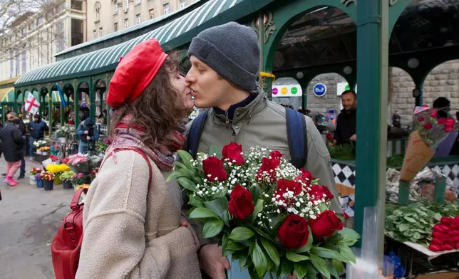 FILE - A couple share a tender moment near a flower market celebrating International Women's Day in Tbilisi, Georgia, March 8, 2022. (AP Photo/Shakh Aivazov, File)