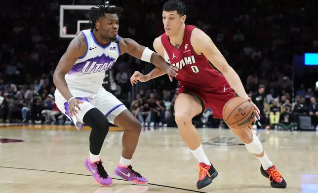 Miami Heat forward Simone Fontecchio (0) dribbles the ball as Utah Jazz guard Isaiah Collier (8) defends during the first half of an NBA basketball game Monday, Feb. 9, 2026, in Miami. (AP Photo/Marta Lavandier)