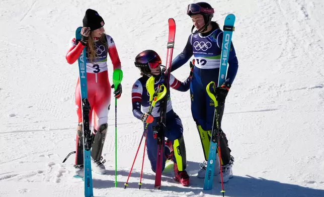 United States' Mikaela Shiffrin, center, winner of an alpine ski, women's slalom race, celebrates with second-placed Switzerland's Camille Rast, left, and third-placed Sweden's Anna Swenn Larsson, at the 2026 Winter Olympics, in Cortina d'Ampezzo, Italy, Wednesday, Feb. 18, 2026. (AP Photo/Andy Wong)