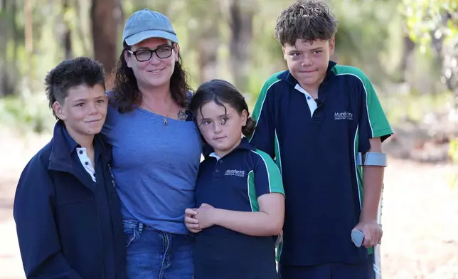 Austin Appelbee, right, poses with his brother, Beau, left, his mother, Joanne, second left, and sister Grace, in Gidgegannup, Australia, Tuesday Feb. 3, 2026, after 13-year-old Austin made an hourslong swim to raise an alarm after his family was swept out to sea off the Australian coast. (Briana Shepherd/ABC via AP)