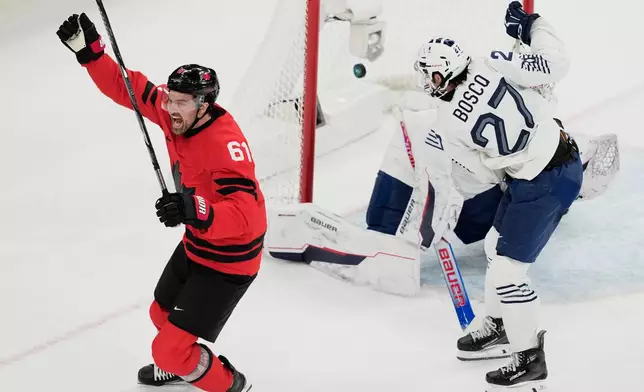 Canada's Mark Stone (61) celebrates after scoring a goal against France's goalkeeper Julian Junca (33) and France's Jules Boscq (27) in the first period during a preliminary round game of men's ice hockey between Canada and France at the 2026 Winter Olympics, in Milan, Italy, Sunday, Feb. 15, 2026. (AP Photo/Hassan Ammar)