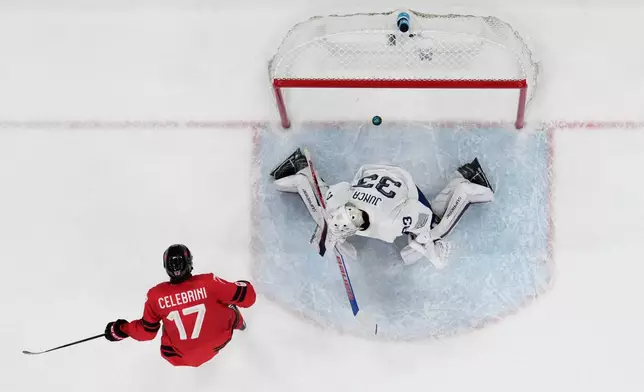 Canada's Macklin Celebrini (17) scores on a penalty shot in the second period against France's goalkeeper Julian Junca (33) during a preliminary round game of men's ice hockey between Canada and France at the 2026 Winter Olympics, in Milan, Italy, Sunday, Feb. 15, 2026. (AP Photo/Carolyn Kaster)