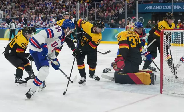 United States' Auston Matthews, right, scores his side's second goal during a preliminary round game of men's ice hockey between the United States and Germany at the 2026 Winter Olympics, in Milan, Italy, Sunday, Feb. 15, 2026. (AP Photo/Carolyn Kaster)