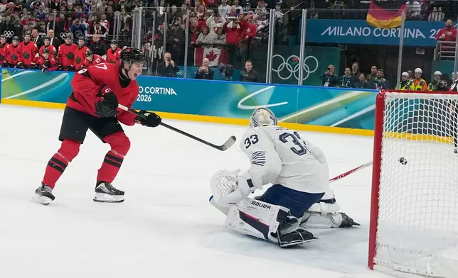 Canada's Macklin Celebrini (17) scores a goal on a penalty shot in the second period against France's goalkeeper Julian Junca (33) during a preliminary round game of men's ice hockey between Canada and France at the 2026 Winter Olympics, in Milan, Italy, Sunday, Feb. 15, 2026. (AP Photo/Hassan Ammar)