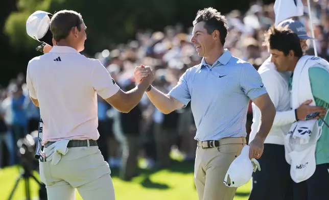 Jacob Bridgeman, left, shakes hands with Rory McIlroy, from Northern Ireland, after winning the Genesis Invitational golf tournament at Riviera Country Club, Sunday, Feb. 22, 2026, in the Pacific Palisades area of Los Angeles. (AP Photo/Caroline Brehman)