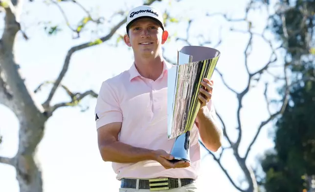 Jacob Bridgeman poses with the winner's trophy after winning the Genesis Invitational golf tournament at Riviera Country Club, Sunday, Feb. 22, 2026, in the Pacific Palisades area of Los Angeles. (AP Photo/Caroline Brehman)