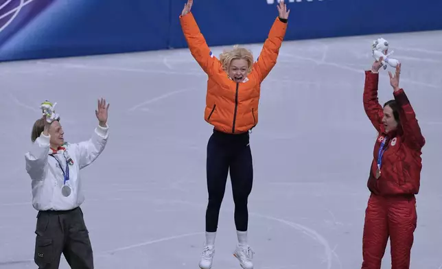 From left to right, silver medalist Arianna Fontana of Italy, gold medalist Xandra Velzeboer of the Netherlands and bronze medalist Courtney Sarault of Canada jump on the podium to receive their medals after the short track speed skating women's 500m at the 2026 Winter Olympics, in Milan, Italy, Thursday, Feb. 12, 2026. (AP Photo/Stephanie Scarbrough)