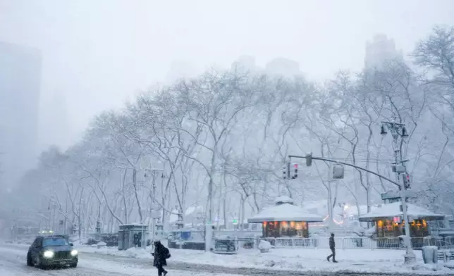 A pedestrian crosses a snow-covered 42nd Street near Bryant Park, Monday, Feb. 23, 2026, in New York. (AP Photo/Seth Wenig)
