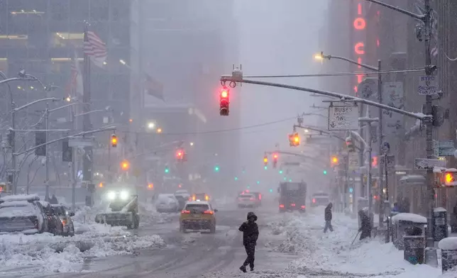 A pedestrian crosses Sixth Avenue during a snow storm, Monday, Feb. 23, 2026, in New York. (AP Photo/Seth Wenig)