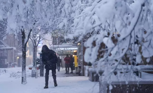 A man walks along a snow-covered sidewalk, Monday, Feb. 23, 2026, in New York. (AP Photo/Seth Wenig)