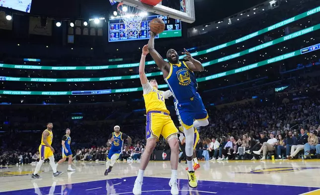 Golden State Warriors forward Draymond Green (23) misses a basket under defense by Los Angeles Lakers forward Jake LaRavia during the first half of an NBA basketball game Saturday, Feb. 7, 2026, in Los Angeles. (AP Photo/Jae C. Hong)