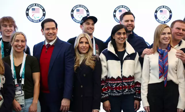 Vice President JD Vance, second lady Usha Vance, Secretary of State Marco Rubio his wife Jeanette Dousdebes Rubio and U.S. Ambassador to Italy and San Marino Tilman Fertitta pose for a photo with Team USA athletes, at the Team USA Welcome Experience, ahead of the Milano Cortina 2026 Winter Olympics in Milan, Italy, Thursday, Feb. 5, 2026. (Kevin Lamarque/Pool Photo via AP)