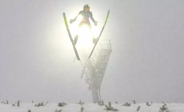 Zhao Zihe, of China, soars through the air during his competition round jump of the nordic combined team sprint at the 2026 Winter Olympics, in Predazzo, Italy, Thursday, Feb. 19, 2026. (AP Photo/Kirsty Wigglesworth)