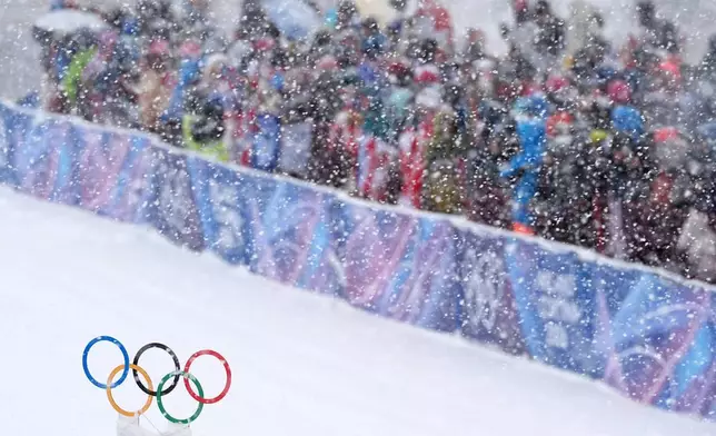 Spectators watch a ski mountaineering men's sprint heat under a snowfall at the 2026 Winter Olympics in Bormio, Italy, Thursday, Feb. 19, 2026. (AP Photo/Rebecca Blackwell)