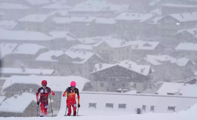 Spain's Oriol Cardona Coll, right, competes alongside Switzerland's Jon Kistler backdropped by a snow covered Bormio village, during a ski mountaineering men's sprint semifinal, at the 2026 Winter Olympics, in Bormio, Italy, Thursday, Feb. 19, 2026. (AP Photo/Rebecca Blackwell)