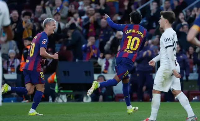 Barcelona's Lamine Yamal (10) celebrates scoring his side's 2nd goal followed by teammate Dani Olmo during the Spanish La Liga soccer match between Barcelona and Mallorca in Barcelona, Spain, Saturday, Feb. 7, 2026. (AP Photo/Joan Monfort)