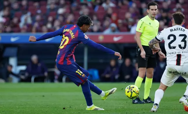 Barcelona's Lamine Yamal, left, scores his side's 2nd goal during the Spanish La Liga soccer match between Barcelona and Mallorca in Barcelona, Spain, Saturday, Feb. 7, 2026. (AP Photo/Joan Monfort)