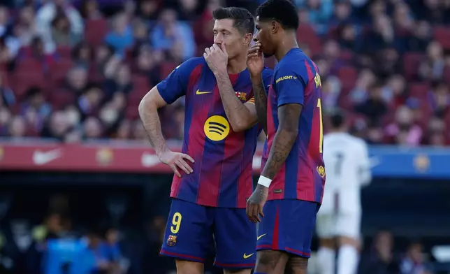 Barcelona's Robert Lewandowski, left, and Marcus Rashford talk during the Spanish La Liga soccer match between Barcelona and Mallorca in Barcelona, Spain, Saturday, Feb. 7, 2026. (AP Photo/Joan Monfort)