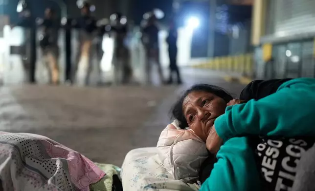 Nelsy Escorcia lies outside the Zone 7 detention center of the Bolivarian National Police, where her husband, Franklin Parra, is being held, as she waits for his release in Caracas, Venezuela, Saturday, Feb. 14, 2026. (AP Photo/Ariana Cubillos)